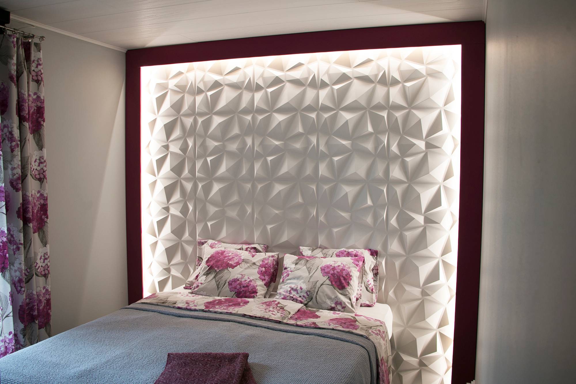 En un dormitorio, la textura de un llamativo cabecero de cama se acentúa con una tira de LED. La tira de leds ilumina con una luz indirecta y suave. Ledstore.fi